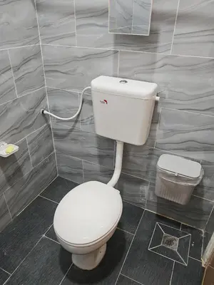 a bathroom with a white toilet and a trash can at Rumah Adaminha, Roomstay with pool Simpang, Taiping in Taiping