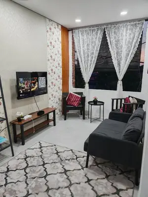 a living room with a couch and a tv at Rumah Adaminha, Roomstay with pool Simpang, Taiping in Taiping