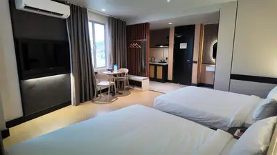 a bedroom with a bed and a table and a kitchen at Urban Inn, Cengal Jaya in Sungai Petani