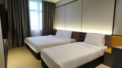 a hotel room with two beds and a window at Urban Inn, Cengal Jaya in Sungai Petani