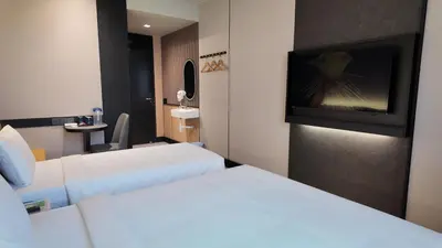 a hotel room with two beds and a flat screen tv at Urban Inn, Cengal Jaya in Sungai Petani