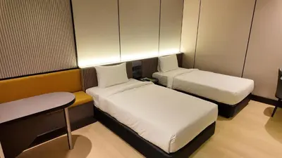 a small room with two beds and a bench at Urban Inn, Cengal Jaya in Sungai Petani