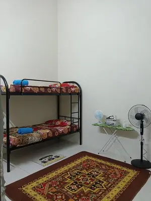 a room with a bunk bed and a rug on the floor at Homestay Ismail LEKIR in Sitiawan