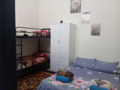 a bedroom with a bed and bunk beds and a cabinet at Homestay Ismail LEKIR in Sitiawan