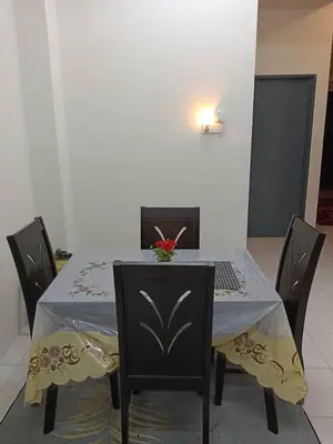 a table with chairs and a laptop on top of it at Homestay Ismail LEKIR in Sitiawan