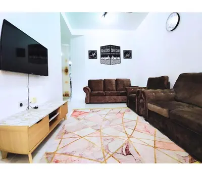 a living room with two couches and a flat screen tv at The Silverlakes Homestay in Batu Gajah