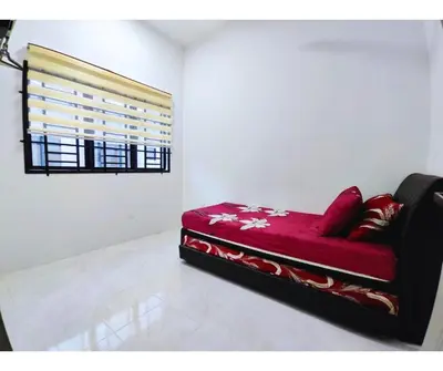 a red couch in a room with a window at The Silverlakes Homestay in Batu Gajah
