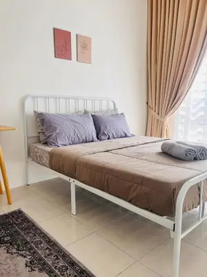 a bed in a bedroom with a white frame at Malaiqqa Homestay in Chemor