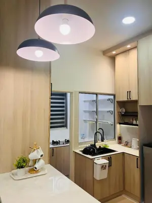 a kitchen with two large lights above a counter at Malaiqqa Homestay in Chemor