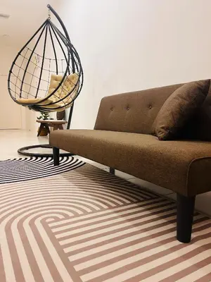 a couch sitting in a living room with a rug at Malaiqqa Homestay in Chemor