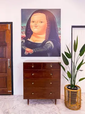 a painting of a woman on a wall next to a dresser at Lakeside Pool Villa in LakeGarden & Zoo in Taiping
