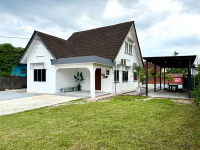 a white house with a black roof and a yard at Lakeside Pool Villa in LakeGarden & Zoo in Taiping