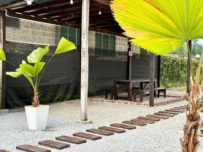 a patio with a table and two plants and a yellow fan at Lakeside Pool Villa in LakeGarden & Zoo in Taiping
