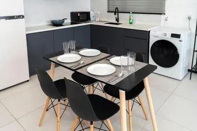 a kitchen with a table with chairs and a dishwasher at Creamy French at Urban Suite in George Town
