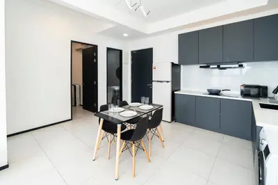 a kitchen with black cabinets and a table and chairs at Creamy French at Urban Suite in George Town
