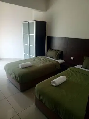 a bedroom with two beds with green sheets at Marina sunset view in Lumut