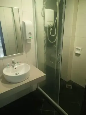 a bathroom with a sink and a shower with a mirror at Marina sunset view in Lumut