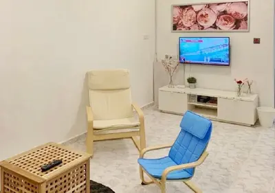 a living room with two chairs and a tv at Ria Serene Homestay in Sungai Petani