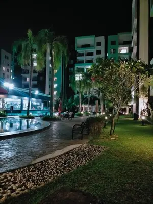 a park at night with palm trees and buildings at Bern's Homestay Manhattan Condo, Ipoh-GROUND FLOOR, POOLSIDE, FREE PARKING and WiFi in Ipoh