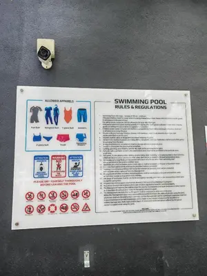 a sign for a swimming pool tables and restrooms at Urban Suite in George Town