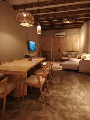 a living room with a large wooden table and chairs at Mokū Georgetown Pre-war House 4BR 5-14pax in George Town