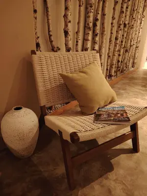 a wicker chair with a pillow and a magazine at Mokū Georgetown Pre-war House 4BR 5-14pax in George Town