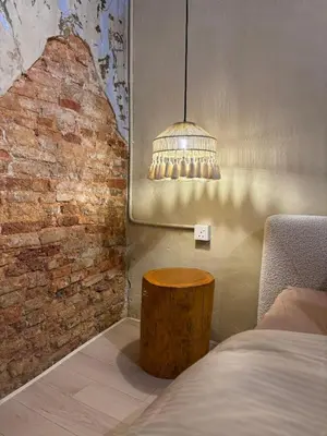 a room with a bed and a table and a lamp at Mokū Georgetown Pre-war House 4BR 5-14pax in George Town