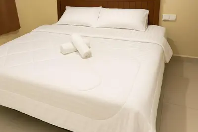 a white bed with two white towels on it at Home2Stay at Marina Island in Lumut