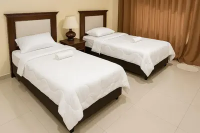two beds in a hotel room with white sheets at Home2Stay at Marina Island in Lumut