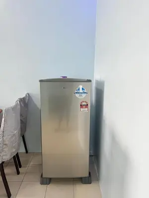 a refrigerator in a room with a table and a chair at AYAAN Fifa Game HOMESTAY At Tanah Rata with Wifi in Tanah Rata