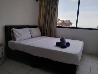a bedroom with a bed with a stuffed animal on it at sri sayang apartment in Batu Ferringhi