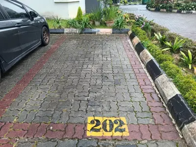 a car parked on a brick driveway with a sign at Imagine world quintet apartment in Tanah Rata