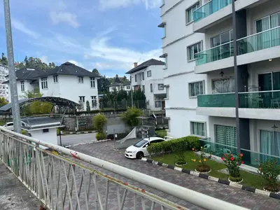 a car parked in a parking lot next to a building at Imagine world quintet apartment in Tanah Rata