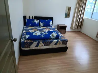 a bedroom with a bed with blue sheets and a wooden floor at Imagine world quintet apartment in Tanah Rata