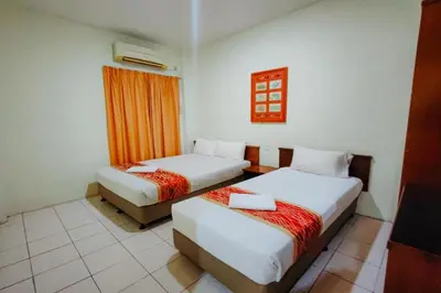 a hotel room with two beds and a window at Virgo Batik Resort, Teluk Batik in Lumut