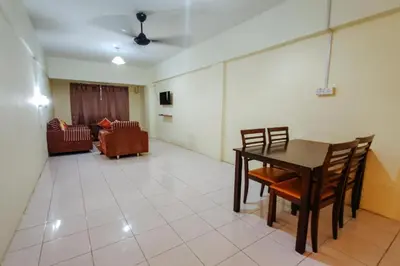 a living room with a table and chairs and a couch at Virgo Batik Resort, Teluk Batik in Lumut