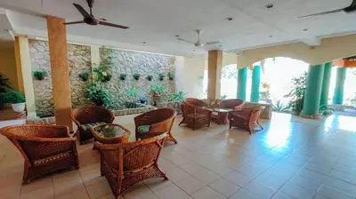 a dining room with wicker chairs and a table at Virgo Batik Resort, Teluk Batik in Lumut