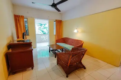 a living room with wicker chairs and a table and a window at Virgo Batik Resort, Teluk Batik in Lumut