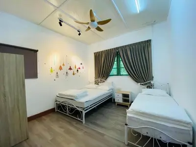 a bedroom with two beds and a ceiling fan at BANGALOW Cameron Highlands in Tanah Rata