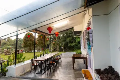 an outdoor patio with tables and chairs and lights at BANGALOW Cameron Highlands in Tanah Rata