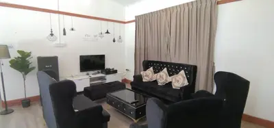 a living room with black chairs and a couch at BANGALOW Cameron Highlands in Tanah Rata