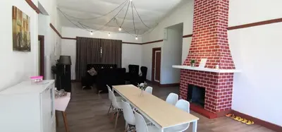 a living room with a table and a brick fireplace at BANGALOW Cameron Highlands in Tanah Rata