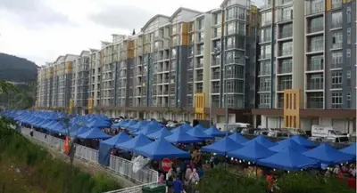 a large building with blue umbrellas in front of it at Golden Hills 2 Bedroom Apartment in Brinchang