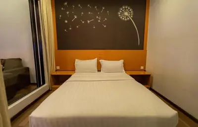 a bedroom with a bed with white sheets and a window at Nova Cameron Glamz in Cameron Highlands