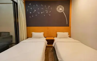 two beds in a room with a picture of a dandelion at Nova Cameron Glamz in Cameron Highlands