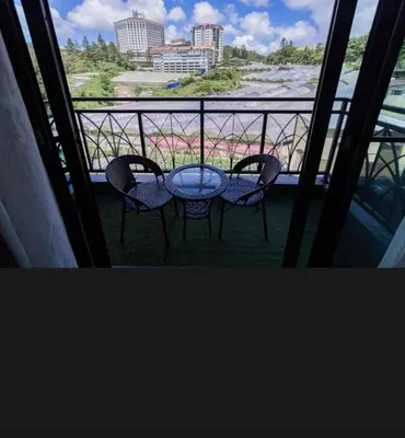 a table and chairs on a balcony with a view at Nova Cameron Glamz in Cameron Highlands