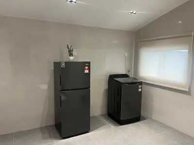 a black refrigerator and a trash can in a room at Canning Home in Ipoh