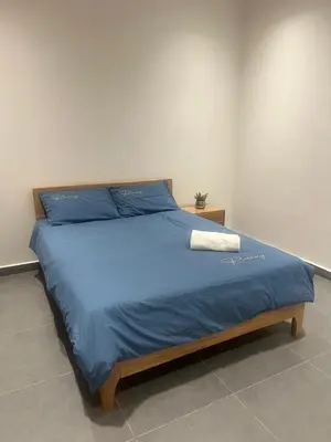 a bedroom with a bed with a blue comforter at Canning Home in Ipoh