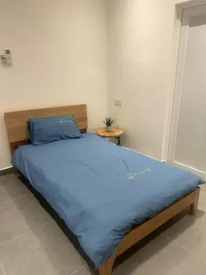 a bedroom with a large bed with a blue blanket at Canning Home in Ipoh