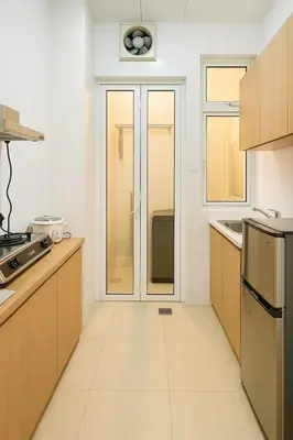 a kitchen with wooden cabinets and a glass door at Riverine Sapphire, 10-3A in Gua Sai